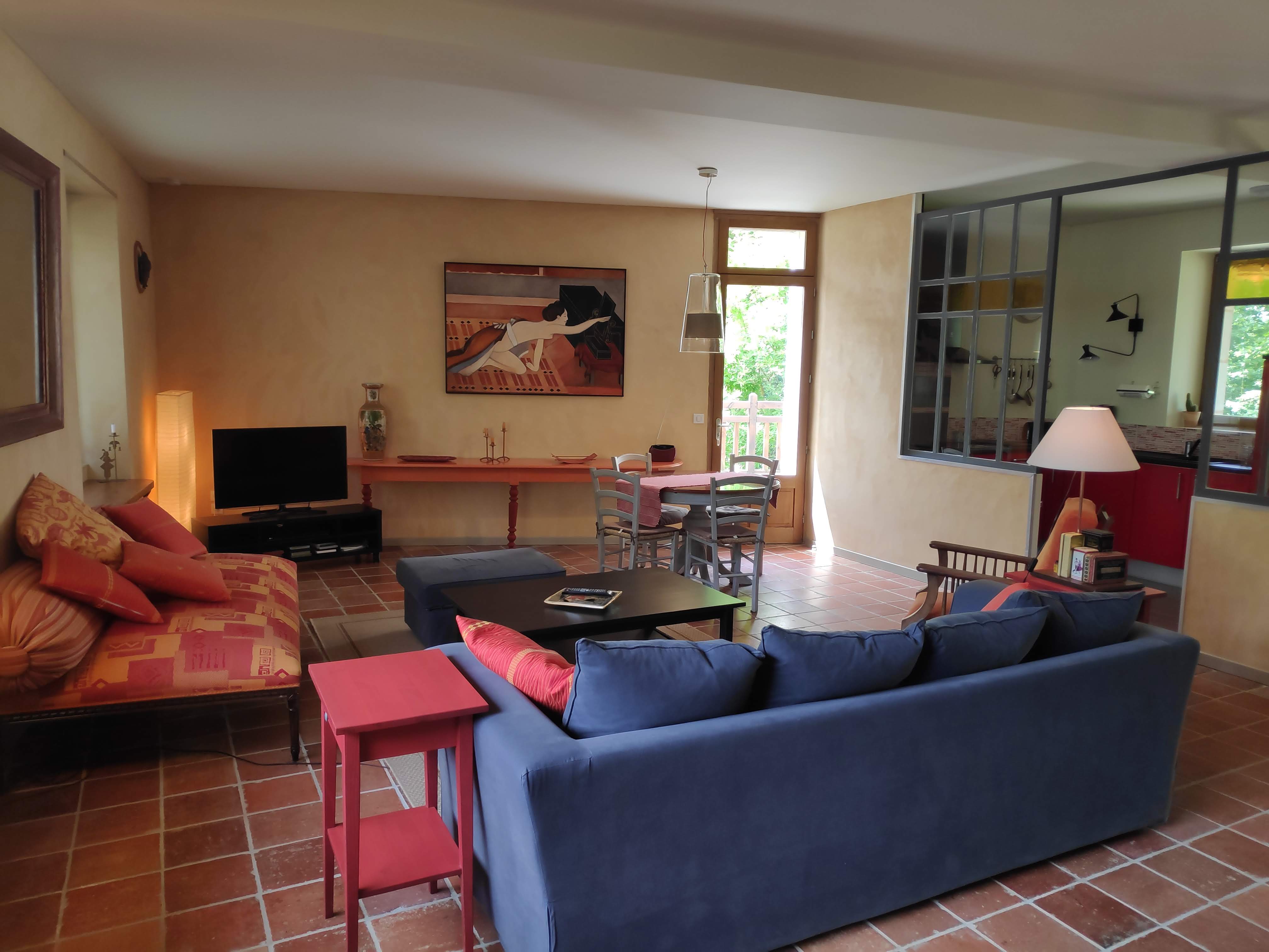 Séjour lumineux avec canapé et TV